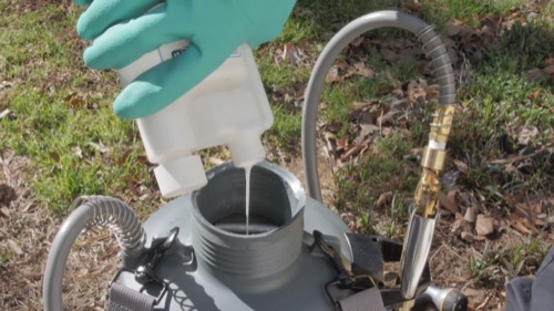 Image of a pest control product being poured into a sprayer tank