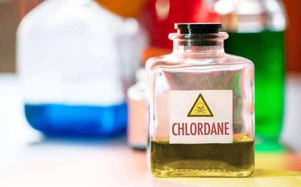 a bottle of chlordane marked as poison on a counter