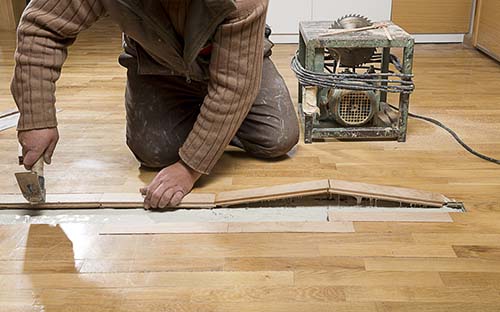 Image of man repairing hardwood flooring