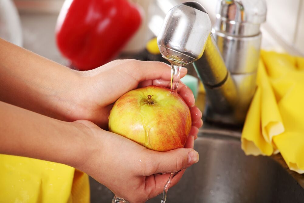 Image showing a person washing an apple at the sink