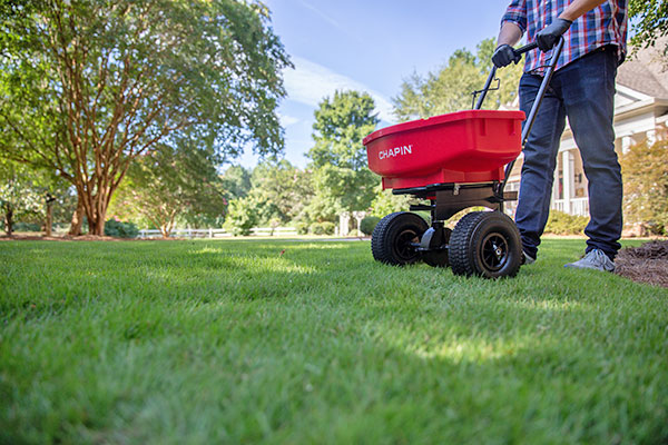 Image of man fertilizing his lawn with a spreader
