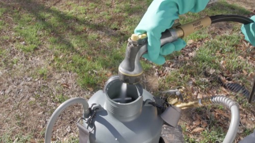 Image of a person adding water to a sprayer